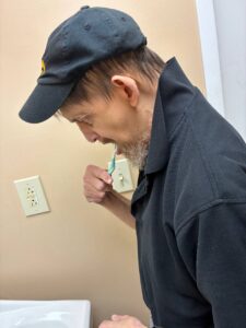Magdala House Adult Day Care Client brushes his teeth during a personal hygiene lesson.