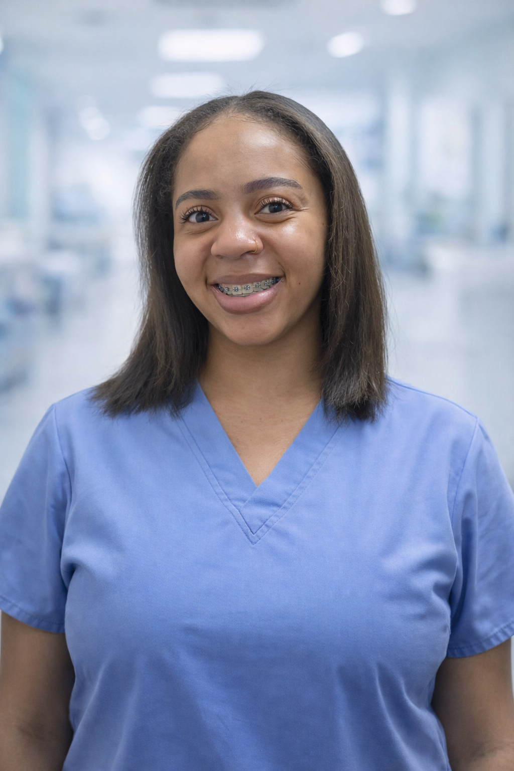 Kauri Johnson, RN, smiling in blue scrubs against a soft medical background